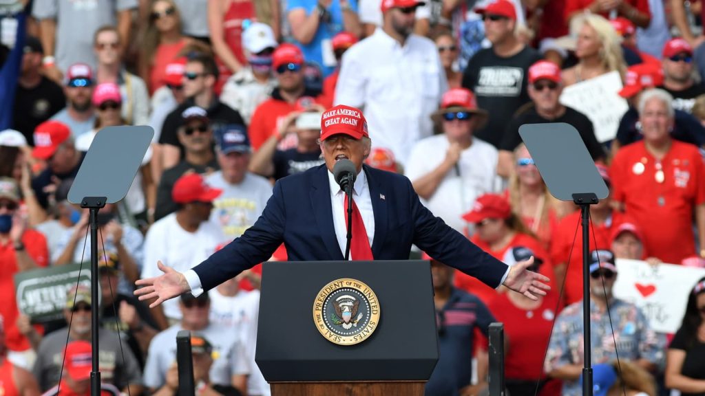 | 1776 | 1791 patriot shops donald trump speaks at a podium with the presidential seal, arms spread, crowd wearing red hats behind him